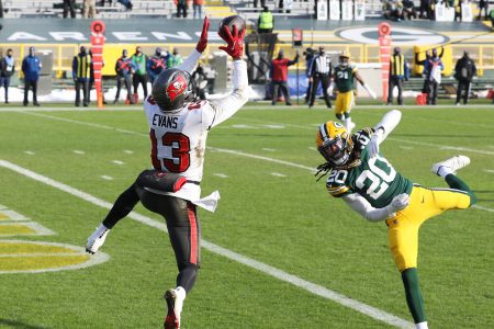 GREEN BAY, WISCONSIN - JANUARY 24: Mike Evans #13 of the Tampa Bay Buccaneers completes a reception for a touchdown in the first quarter against the Green Bay Packers during the NFC Championship game at Lambeau Field on January 24, 2021 in Green Bay, Wisconsin. (Photo by Dylan Buell/Getty Images)
