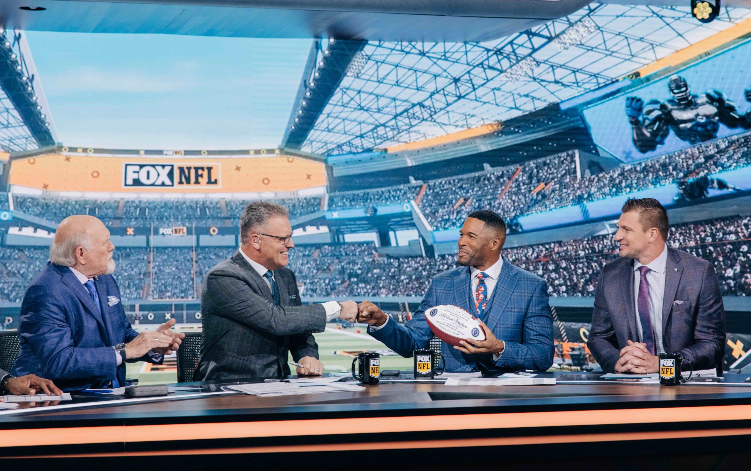 Howie Long fist bumps Strahan as Bradshaw and Gronkowski look on